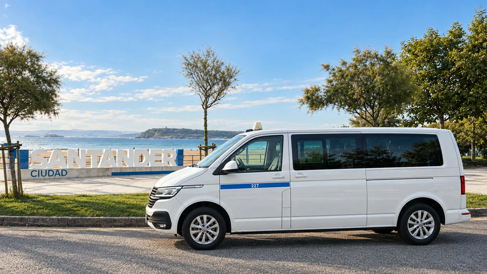 8-seater taxi in front of the Santander letters at El Sardinero, with the beach and sea behind