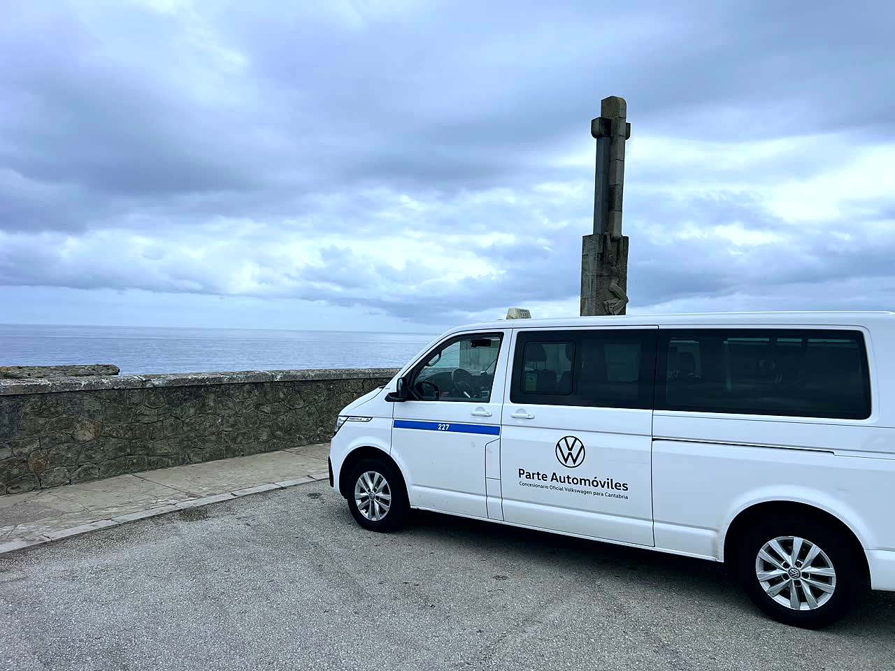 White 8-seater van next to a stone cross and the sea at Cabo Mayor